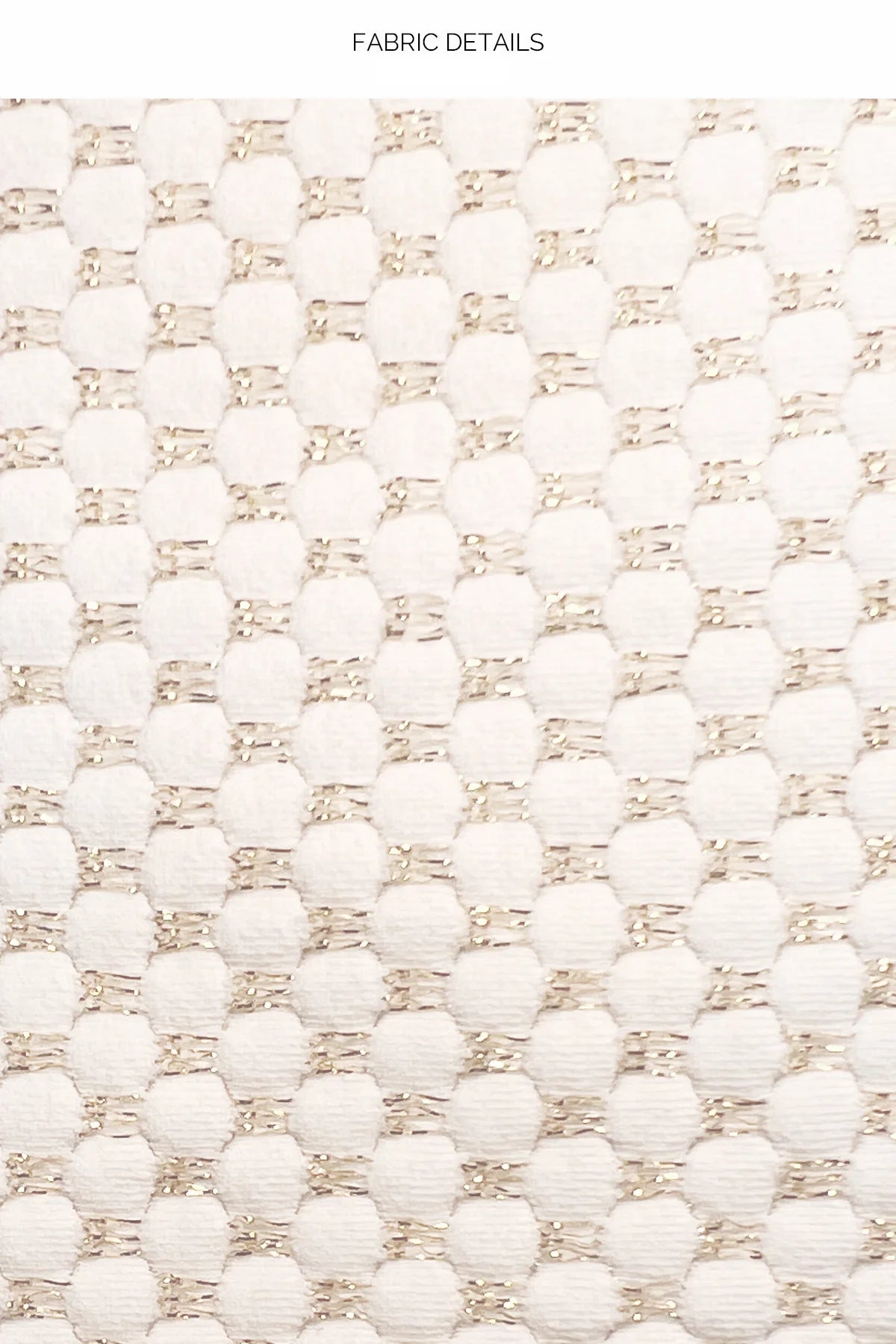 Close-up of a textured fabric with a pattern of white and beige beads.