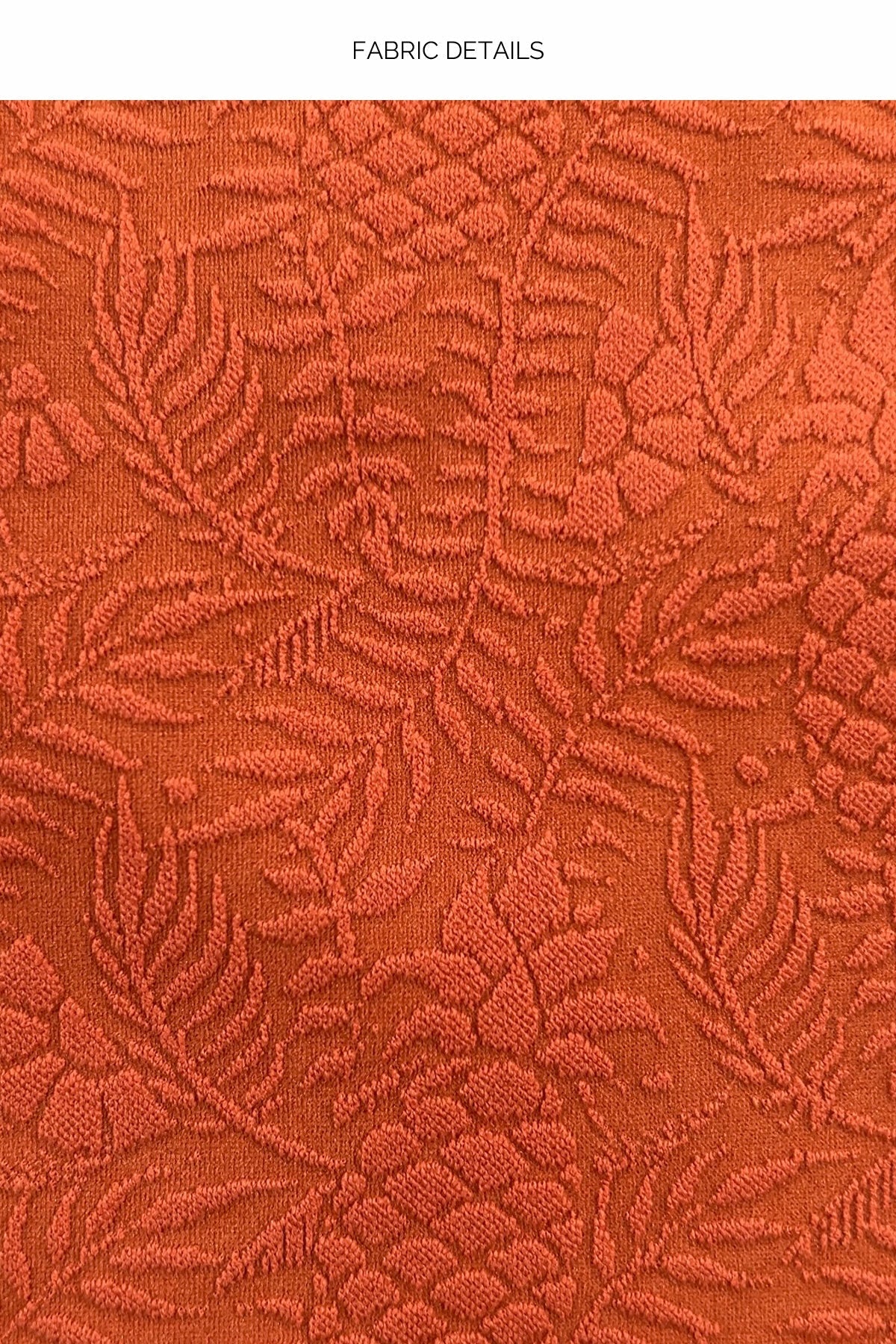 Close-up of textured orange fabric with floral pattern